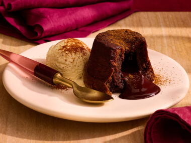 Chilli and chocolate lava cake on plate with spoon and red napkins.