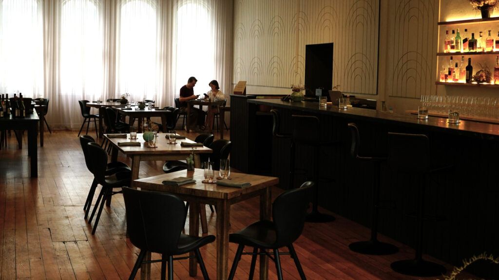 Pneuma restaurant's minimalist dining room with timber and black chairs