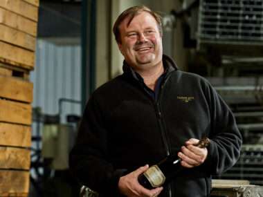 Robert Heywood holding a bottle of Clover Hill wine.