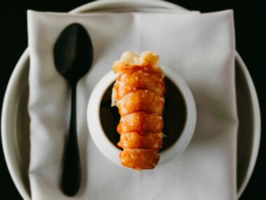 A close-up photo of a plate with marron and steamed egg custard. A black spoon is next to it.