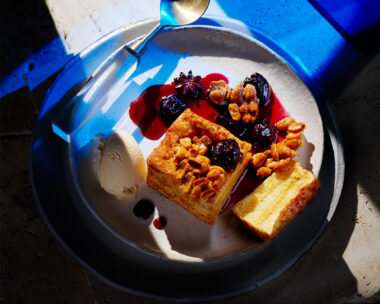 Hong Kong French toast with smoked cinnamon ice-cream and cherry with spoon on blue background.